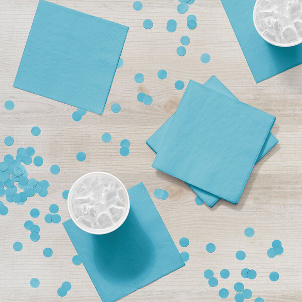 A white table with blue Creative Converting Pastel Blue beverage napkins on it.