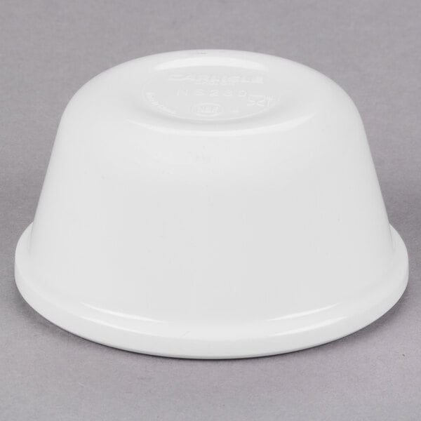 A Carlisle white melamine ramekin on a gray surface.