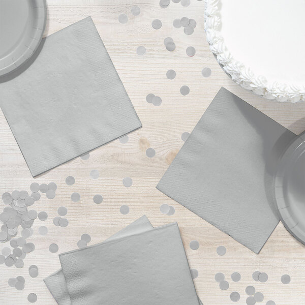 A table set with silver Creative Converting luncheon napkins and plates.