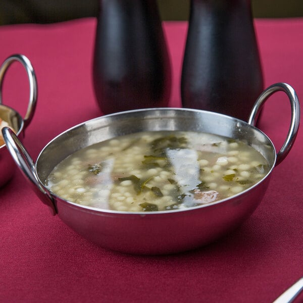 An American Metalcraft stainless steel balti bowl of soup with a spoon in it.