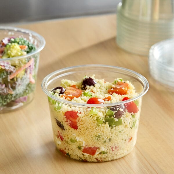A clear 16 oz. round deli container made from recycled PET plastic, filled with couscous salad.