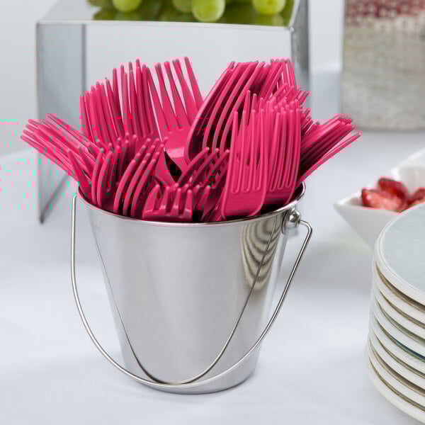 A bucket of pink plastic forks.