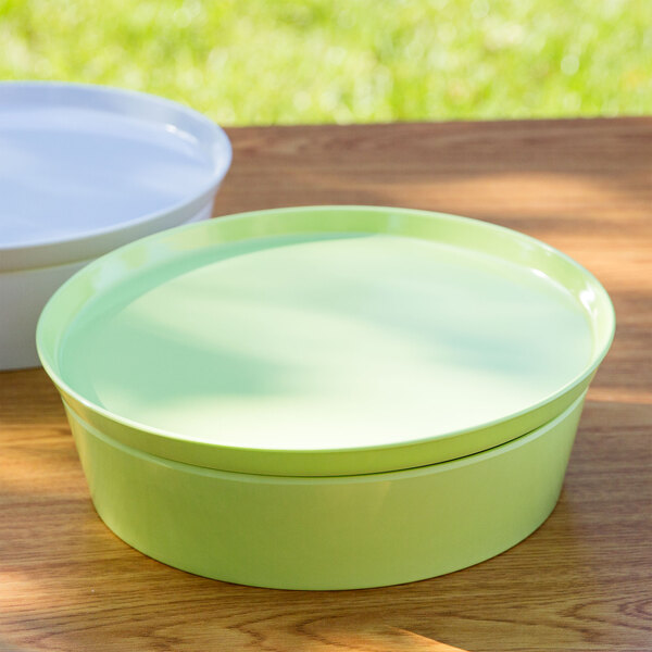 A lime green melamine Cabana bowl set on a wood table.