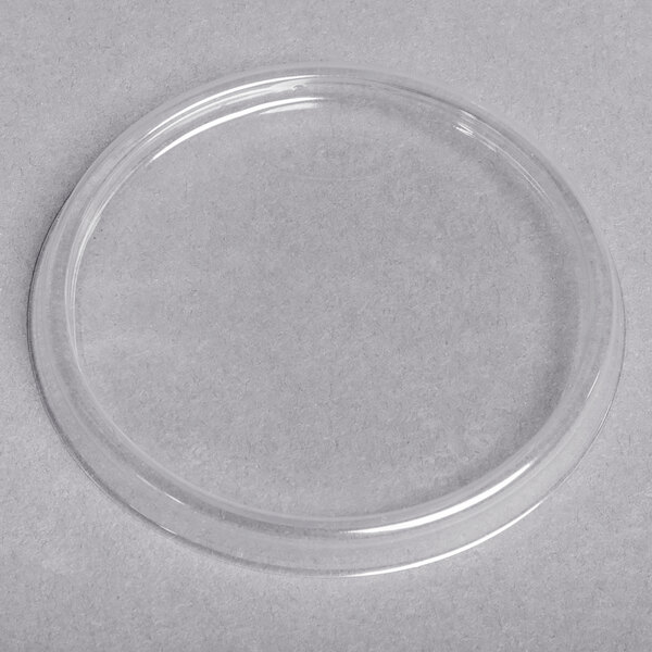 A clear plastic circle lid on a white surface.