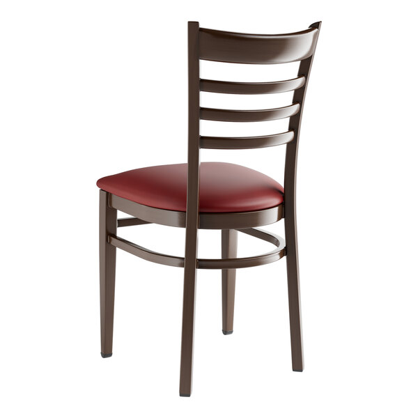 A Lancaster Table & Seating metal ladder back chair with dark walnut wood grain finish and burgundy vinyl seat.