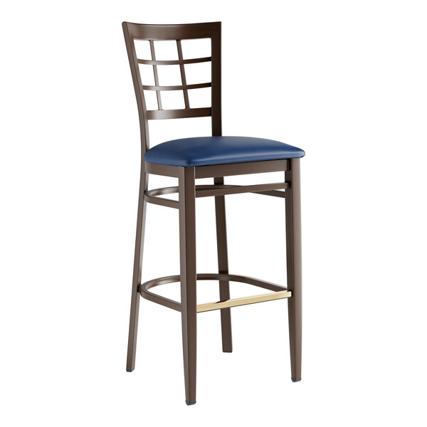 A Lancaster Table & Seating Spartan Series bar stool with dark walnut wood grain finish and navy vinyl seat.