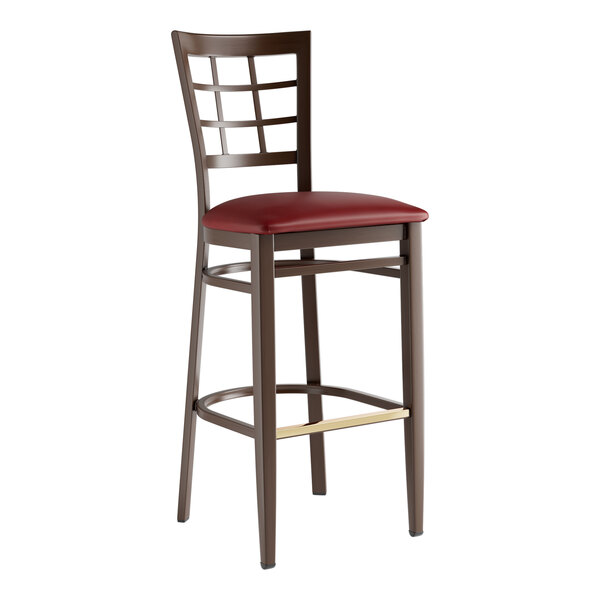 A Lancaster Table & Seating Spartan Series bar stool with dark walnut wood grain finish and a burgundy vinyl seat.