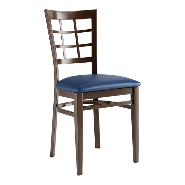 A Lancaster Table & Seating Spartan Series chair with a navy blue cushion and wood grain window back.