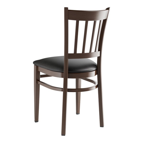 A Lancaster Table & Seating Spartan Series metal chair with dark walnut wood grain finish and black vinyl seat.