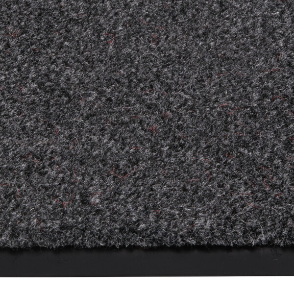 A close-up of a grey Notrax Sabre carpet with black and red spots.