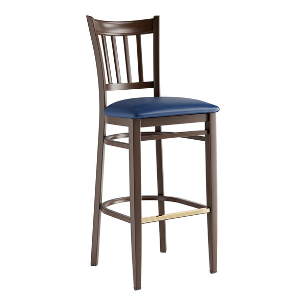 A Lancaster Table & Seating Spartan Series bar stool with a dark walnut wood grain finish and navy vinyl seat.