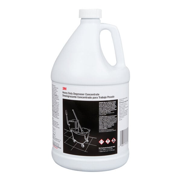 A white plastic gallon jug with a handle and a label indicating it is a heavy duty degreaser concentrate, featuring safety symbols and usage instructions.