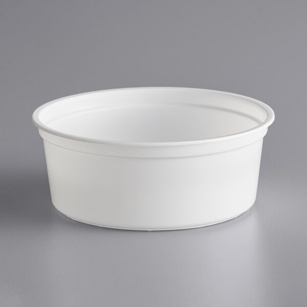 A white plastic container on a gray surface.
