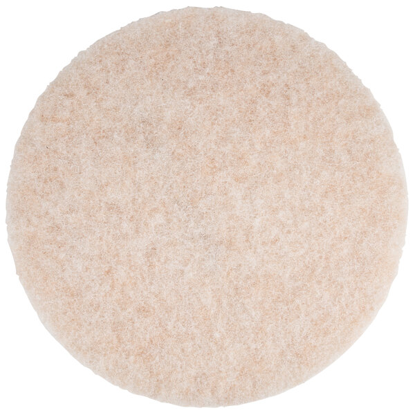 A close up of a round white and beige 3M burnishing pad.