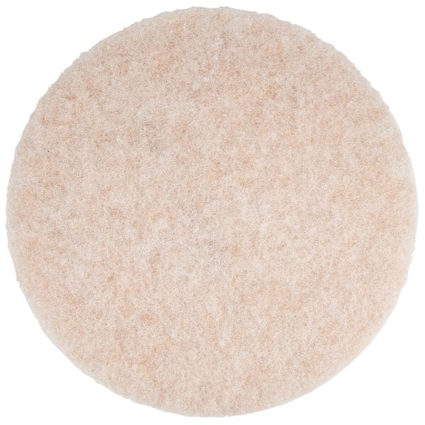 A close up of a round white and beige 3M burnishing pad.