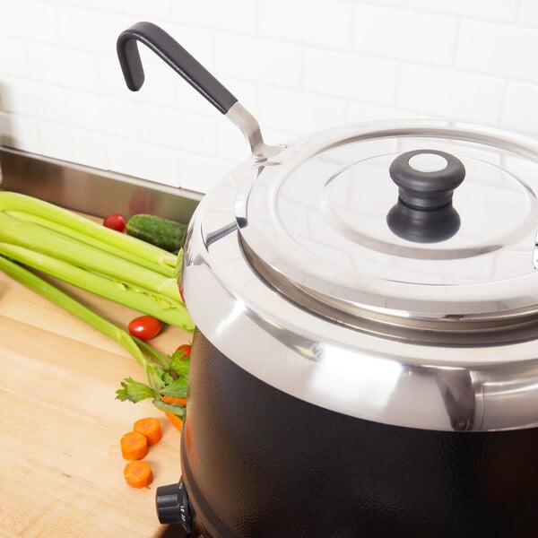 A Vollrath Jacob's Pride stainless steel ladle with a black Kool Touch handle resting in a pot on a counter.