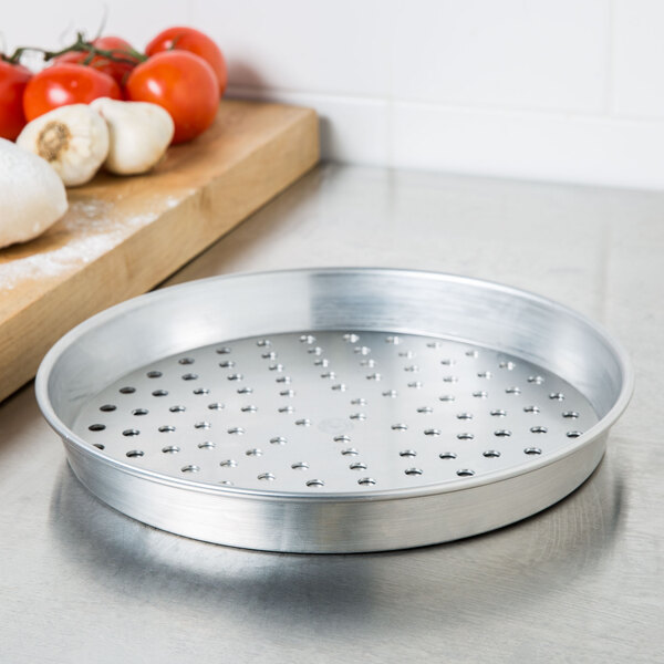 An American Metalcraft silver aluminum pizza pan with perforations.