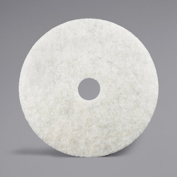 A white circular 3M Natural Blend floor pad with a hole in the middle.