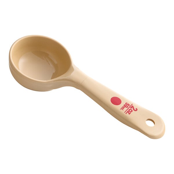A Carlisle beige and red color coding portion spoon with a short handle.