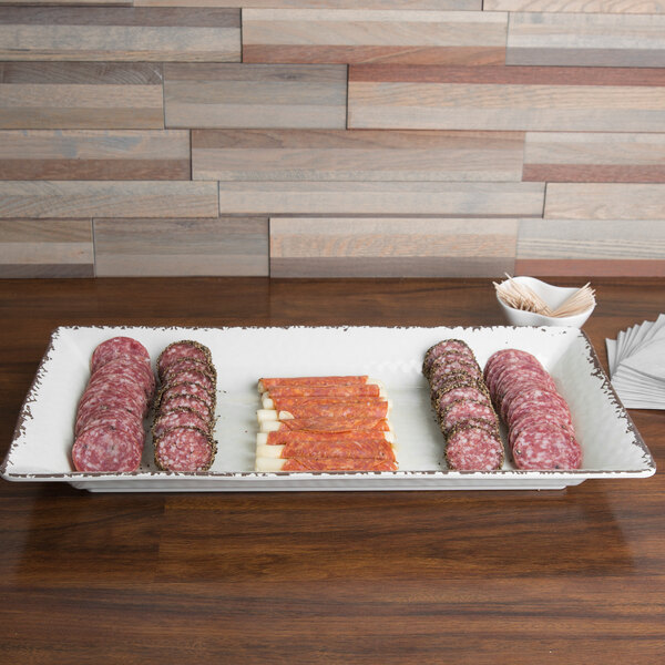 An American Metalcraft Antique White Melamine platter with sliced meat and cheese on it.