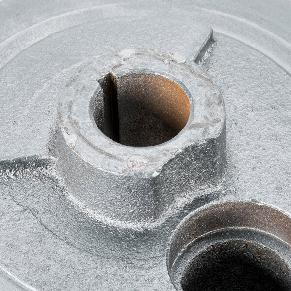 A close-up of a metal turning plate with holes.