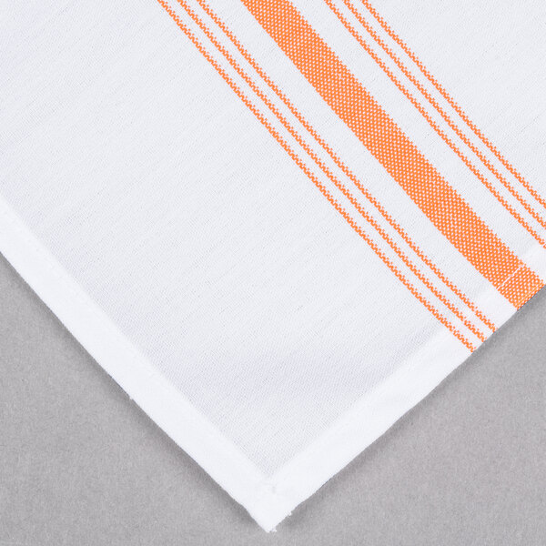 A folded white cloth napkin with orange stripes.
