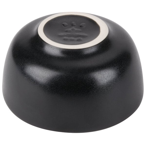 A black Hall China bowl with a white rim.