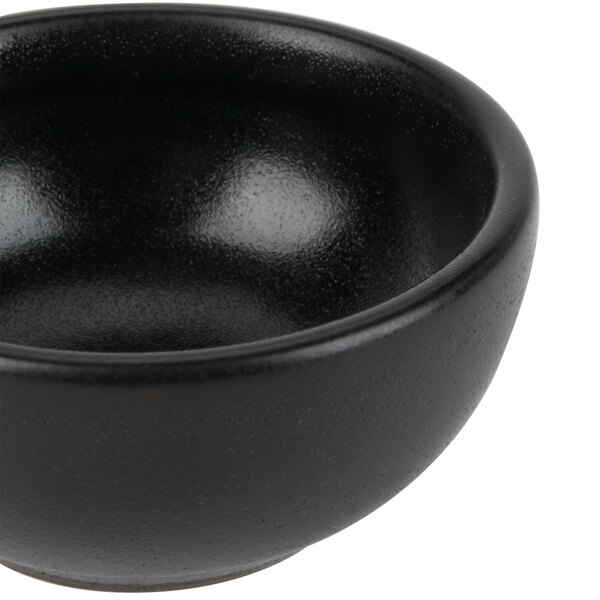 A black Hall China ramekin with a white interior.