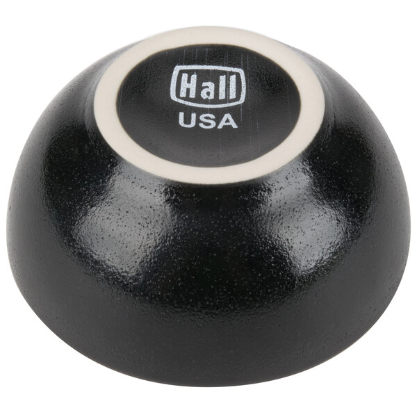 A black Hall China ramekin with white text on it.