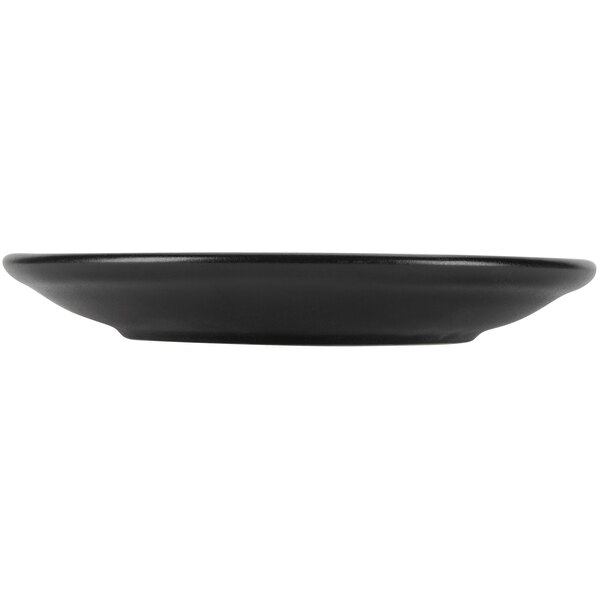 A Hall China Foundry black coupe plate with a rim on a white background.