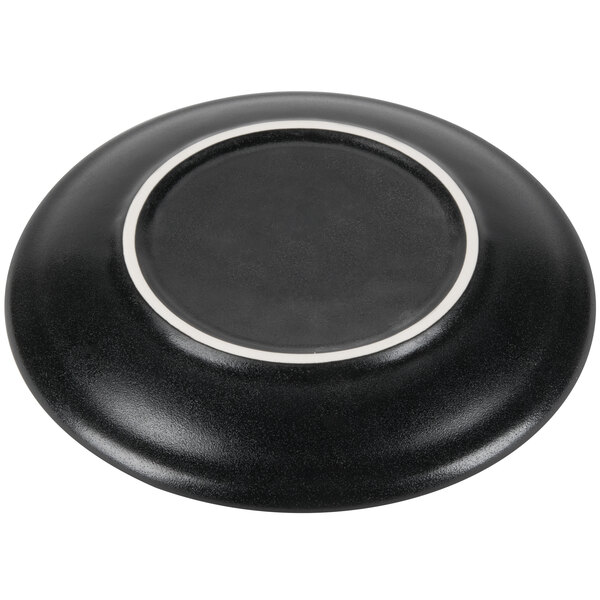 A close-up of a black Hall China Foundry round coupe plate with a white border.