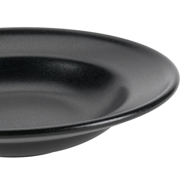 A close-up of a black Hall China Mediterranean rim soup bowl.