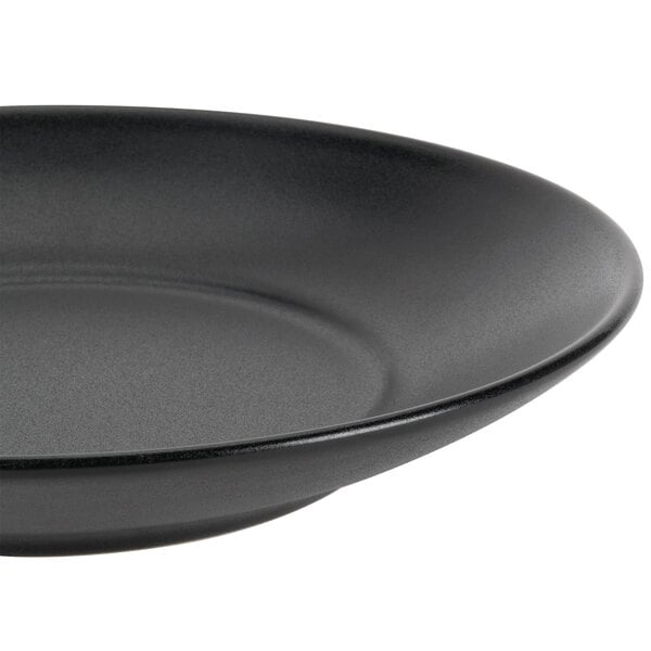 A close-up of a black Hall China bowl with a rim.