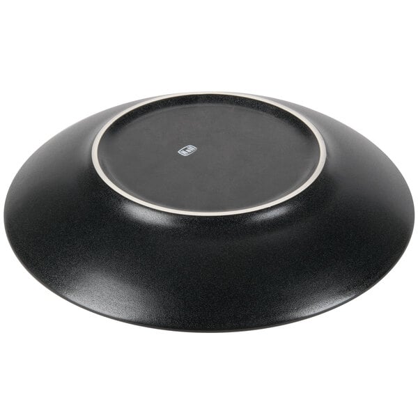 A black Hall China bowl with a white border on a table.