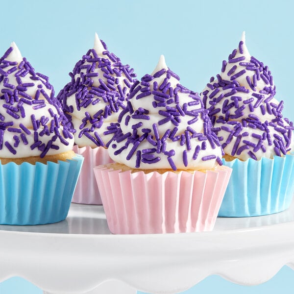 A group of cupcakes with purple and blue Adourne sprinkles on top.