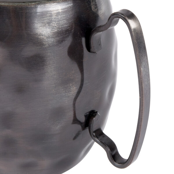 A close-up of a Libbey hammered antique copper metal mug with a handle.