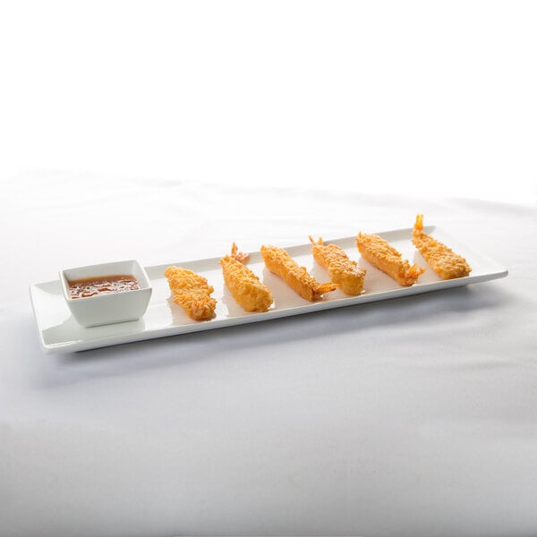 A Libbey ultra bright white rectangular porcelain tray with fried shrimp and dipping sauce.