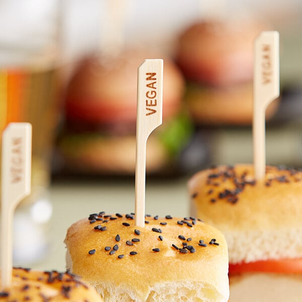 A plate of small sandwiches with Tablecraft vegan food markers.