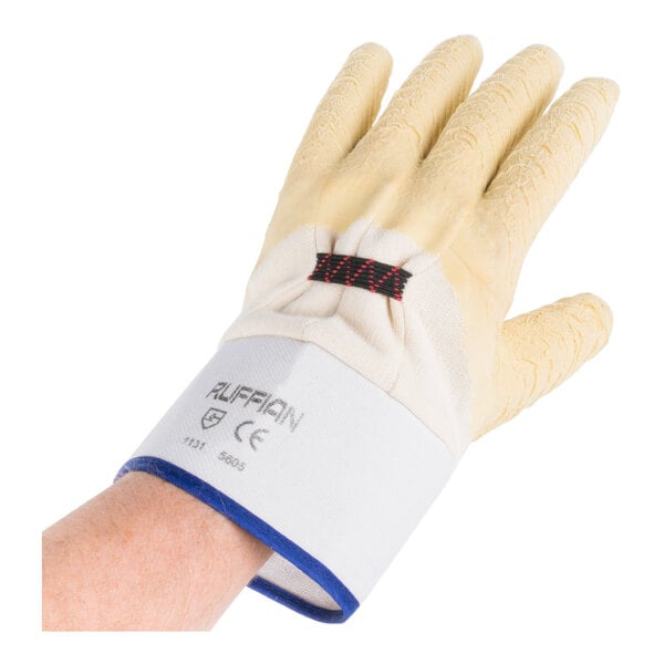 A hand wearing a Cordova Ruffian oyster shucking glove with yellow and blue trim.