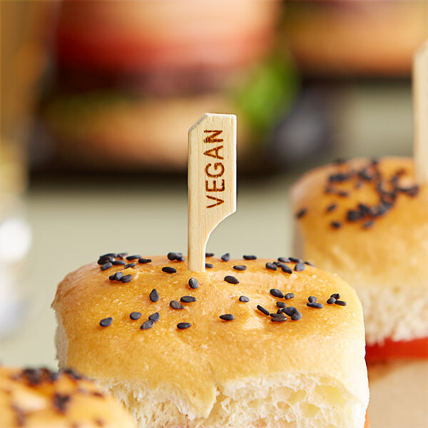 A sandwich with a Tablecraft wood pick topped with a small piece of paper.