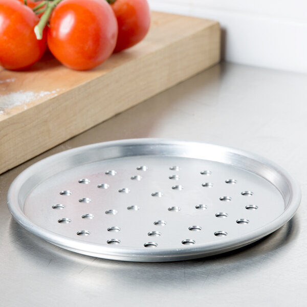 An American Metalcraft heavy weight aluminum pizza pan with holes.