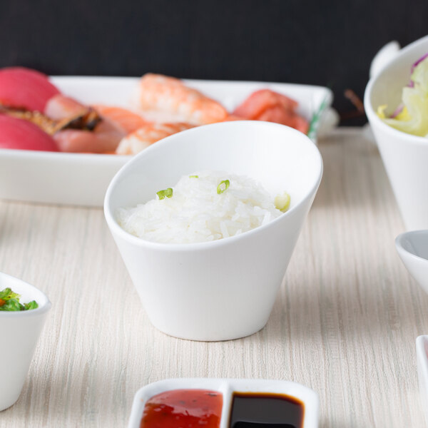 A white table with 10 Strawberry Street Whittier tall slant bowls filled with food and a bowl of sauce.