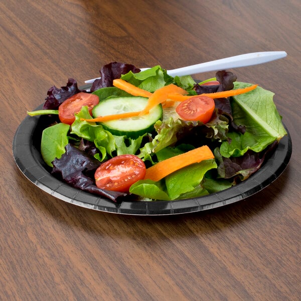 A plate of salad with a black velvet paper plate and a fork.