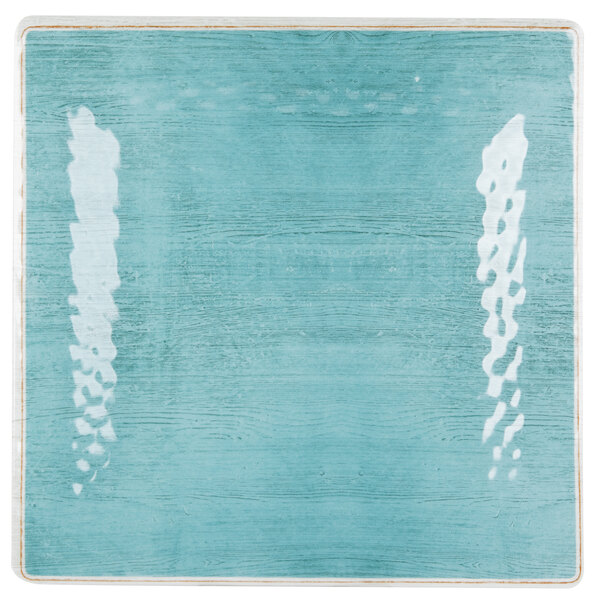 Aqua square melamine plate with white lines on a blue surface.