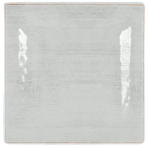 A white square Carlisle melamine plate with a brown border.