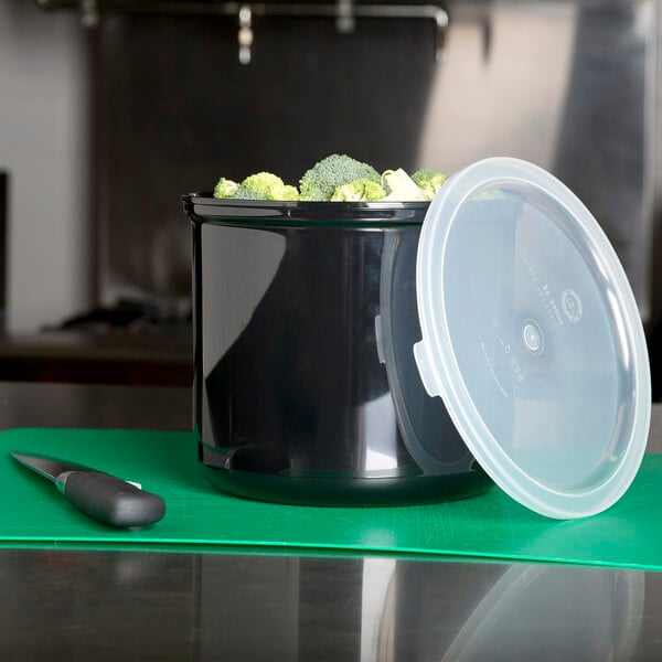 A Carlisle black plastic crock with broccoli and a knife inside.