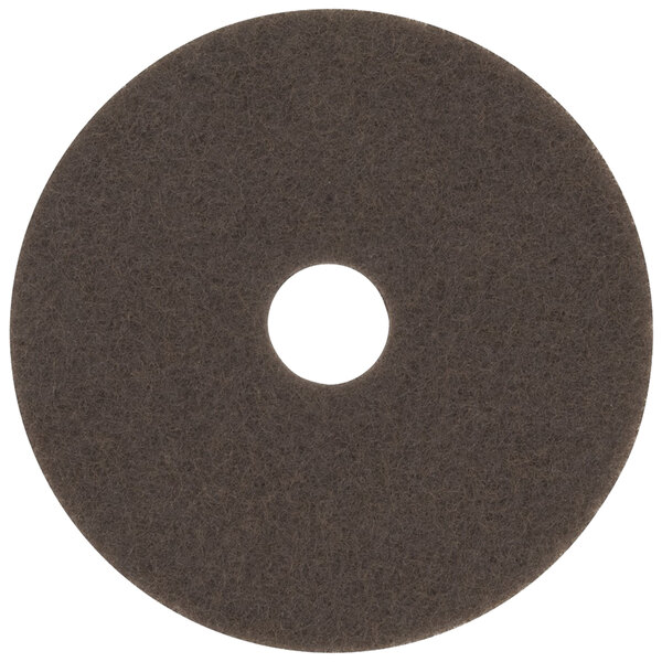 A brown 3M stripping pad with a hole in the middle.