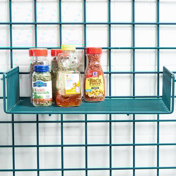 A Metro SmartWall shelf with clear containers of herbs and spices on it.