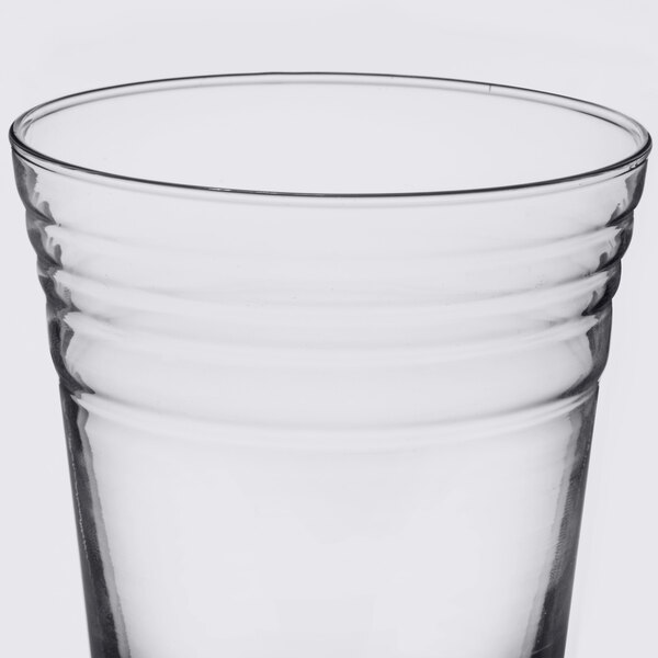 An Arcoroc clear glass with a rim on a white background.