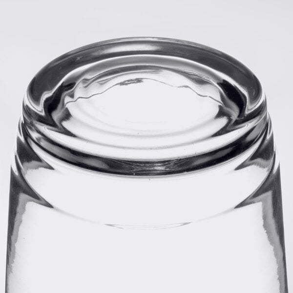 A close-up of a clear Arcoroc party glass with a small hole in it.